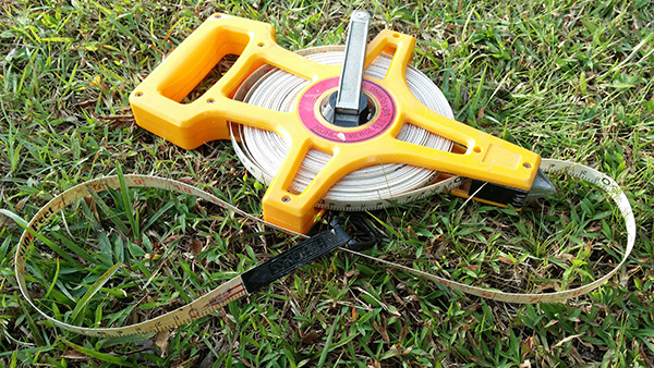 Tape measure in the grass of a homeowners backyard